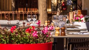 A dining table set with wine glasses, a salt and pepper shaker, and a red flower pot.