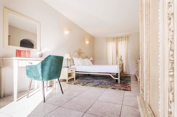 A hotel room with a bed, a desk, a chair, a mirror, and a window with curtains. - Osteria A Stalla Sischese & Spa (Sisco)