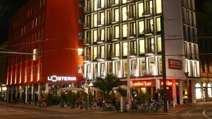 A multi-story hotel with a prominent 'CITYHOTEL' sign, a 'LOSTERIA' restaurant, and a 'mini bar' on the ground floor. - Smartcity Designhotel (Hannover)