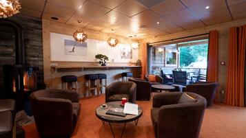 Un rincón lounge acogedor con asientos cómodos, chimenea y barra con taburetes.