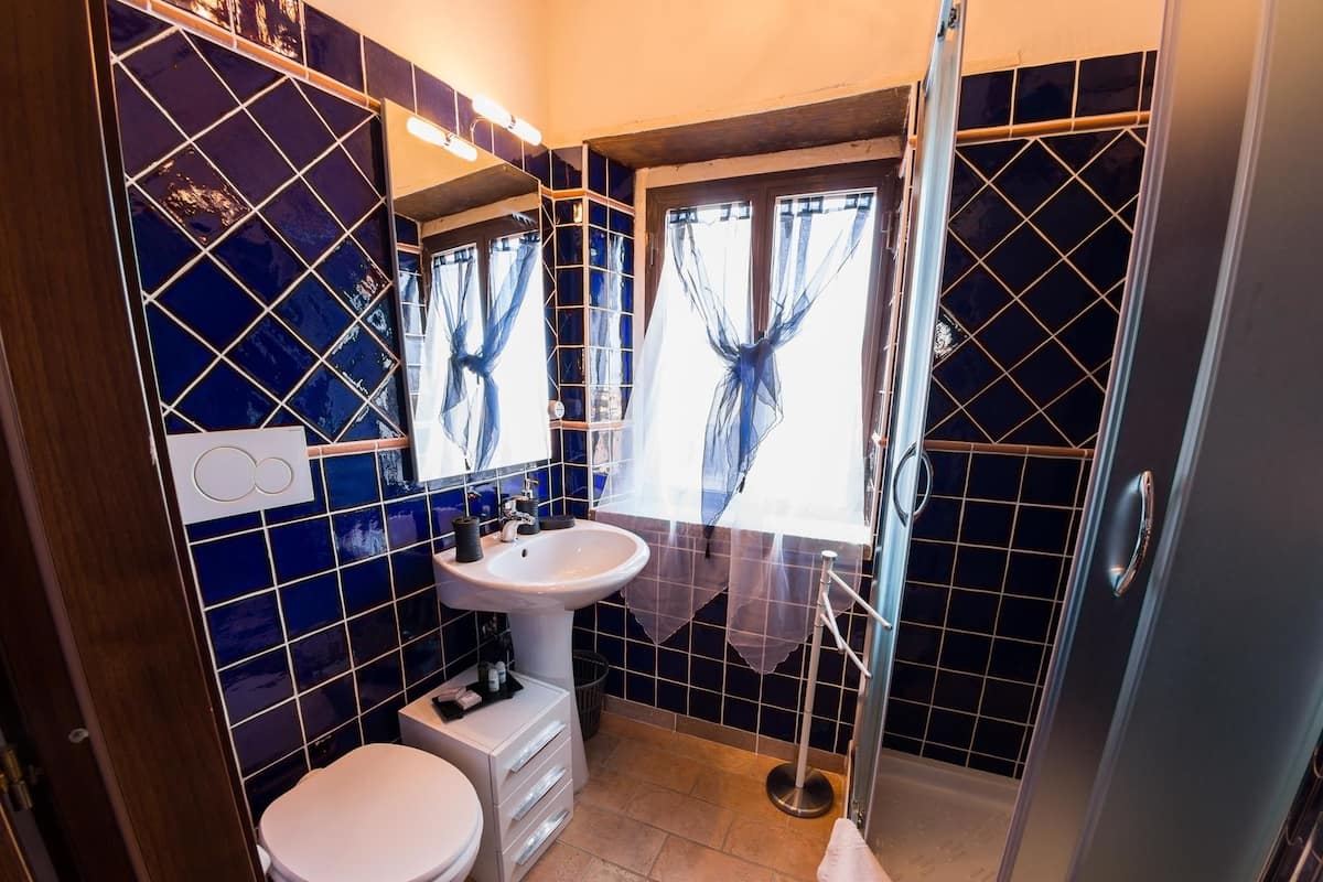 A bathroom with a white sink, a toilet, and a glass shower enclosure.