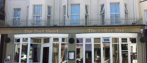 A building with two sections labeled "The Port Hotel" and "The Cellar Bar."