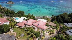 A coastal property with multiple buildings, a swimming pool, and a view of the ocean. - Au Fond De Mer View (Mahé Island)