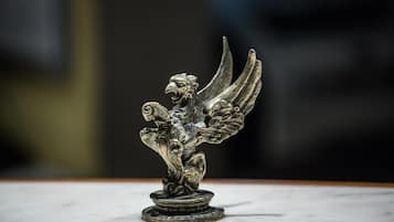 A metallic sculpture of a winged figure on a pedestal.