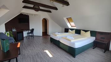 A hotel room with a large bed, a desk, and a chair.