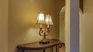 A corner table with two wall-mounted lamps and a decorative base.