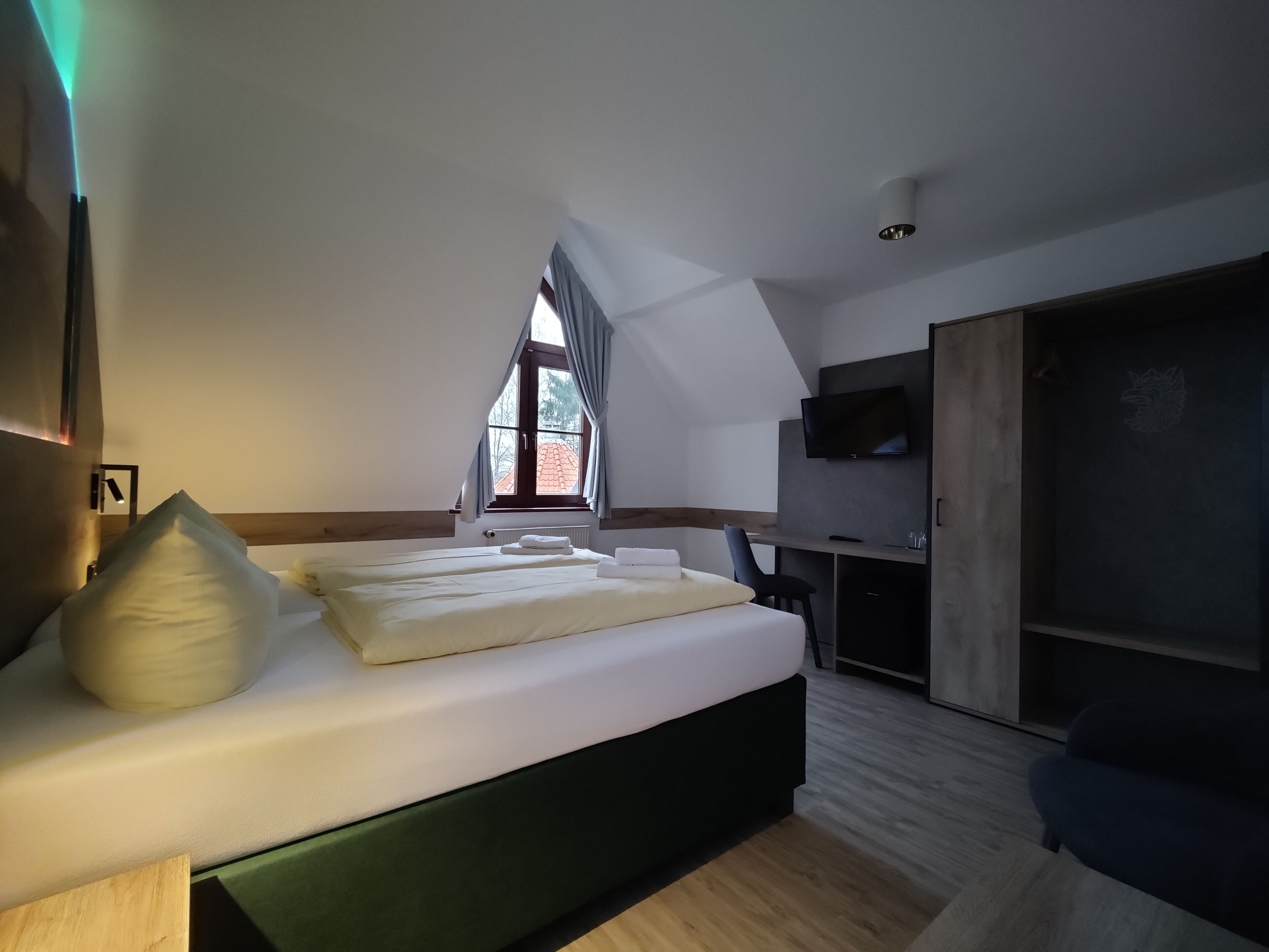 Une chambre moderne avec un grand lit, un bureau et une télévision.
