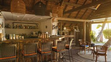 A bar area with wicker chairs and a wooden bar counter.