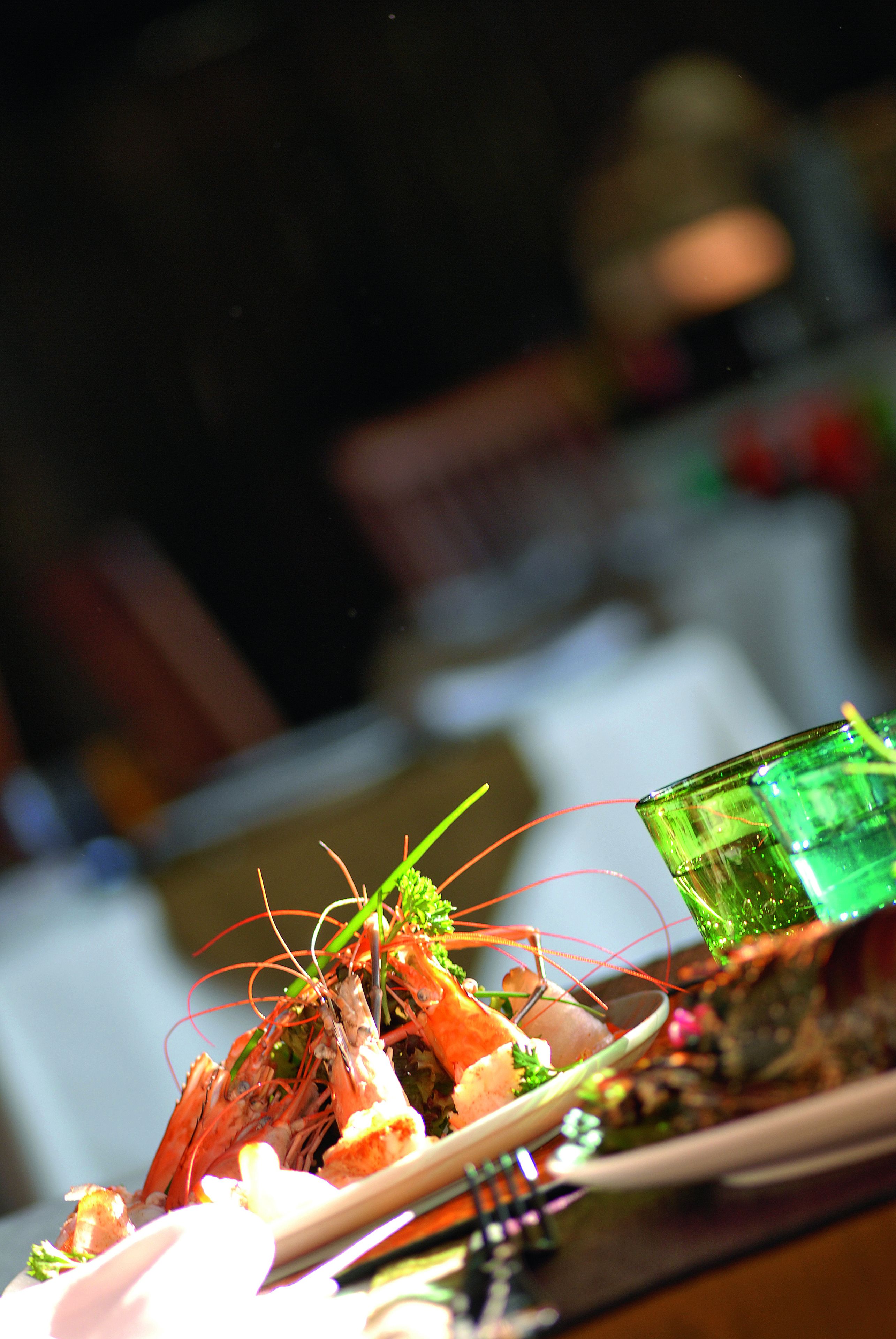 A dining table with a plate of food, a glass of green drink, and chopsticks.