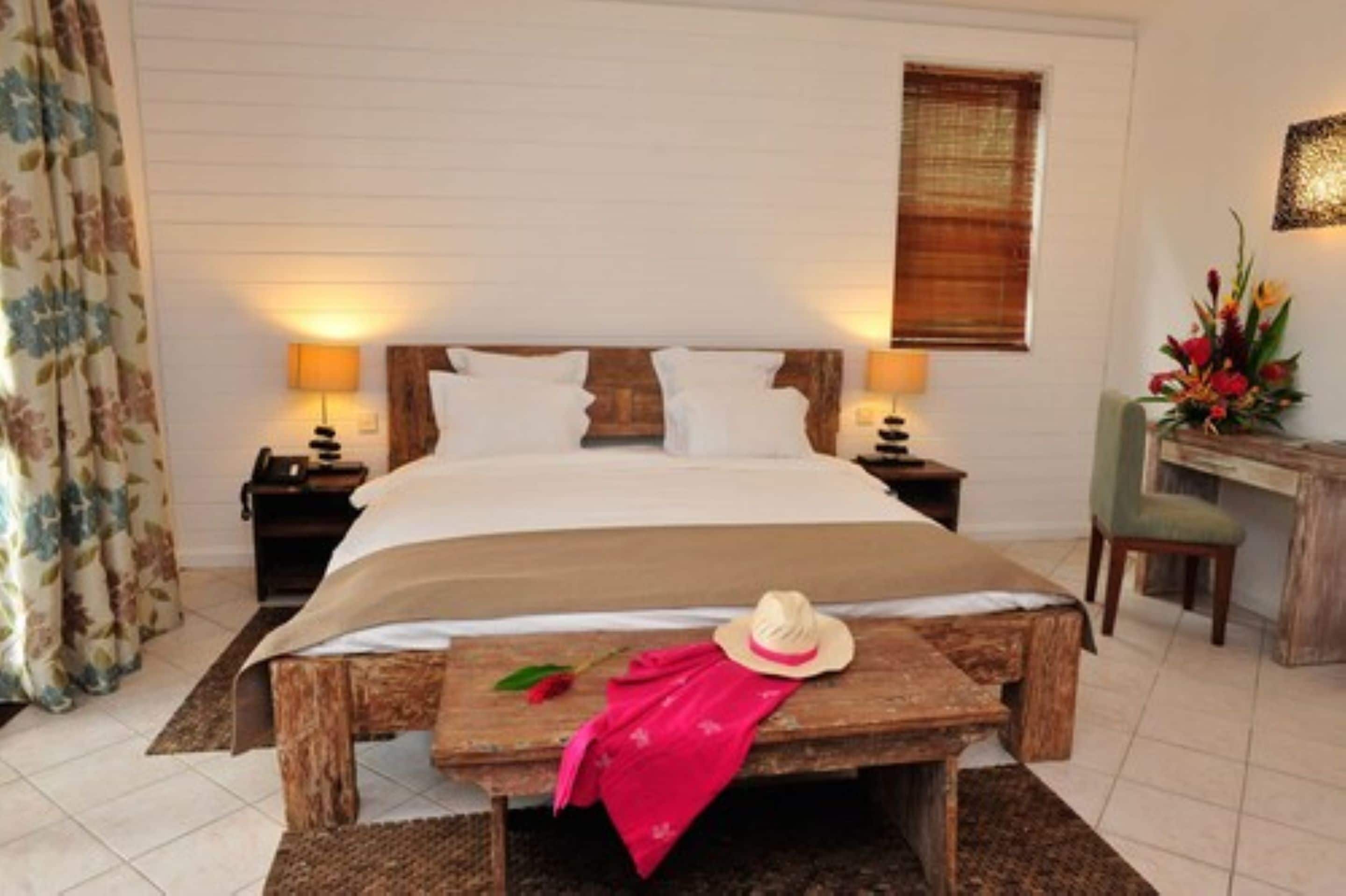 A bedroom with a bed, bedside tables, a desk, and a chair.