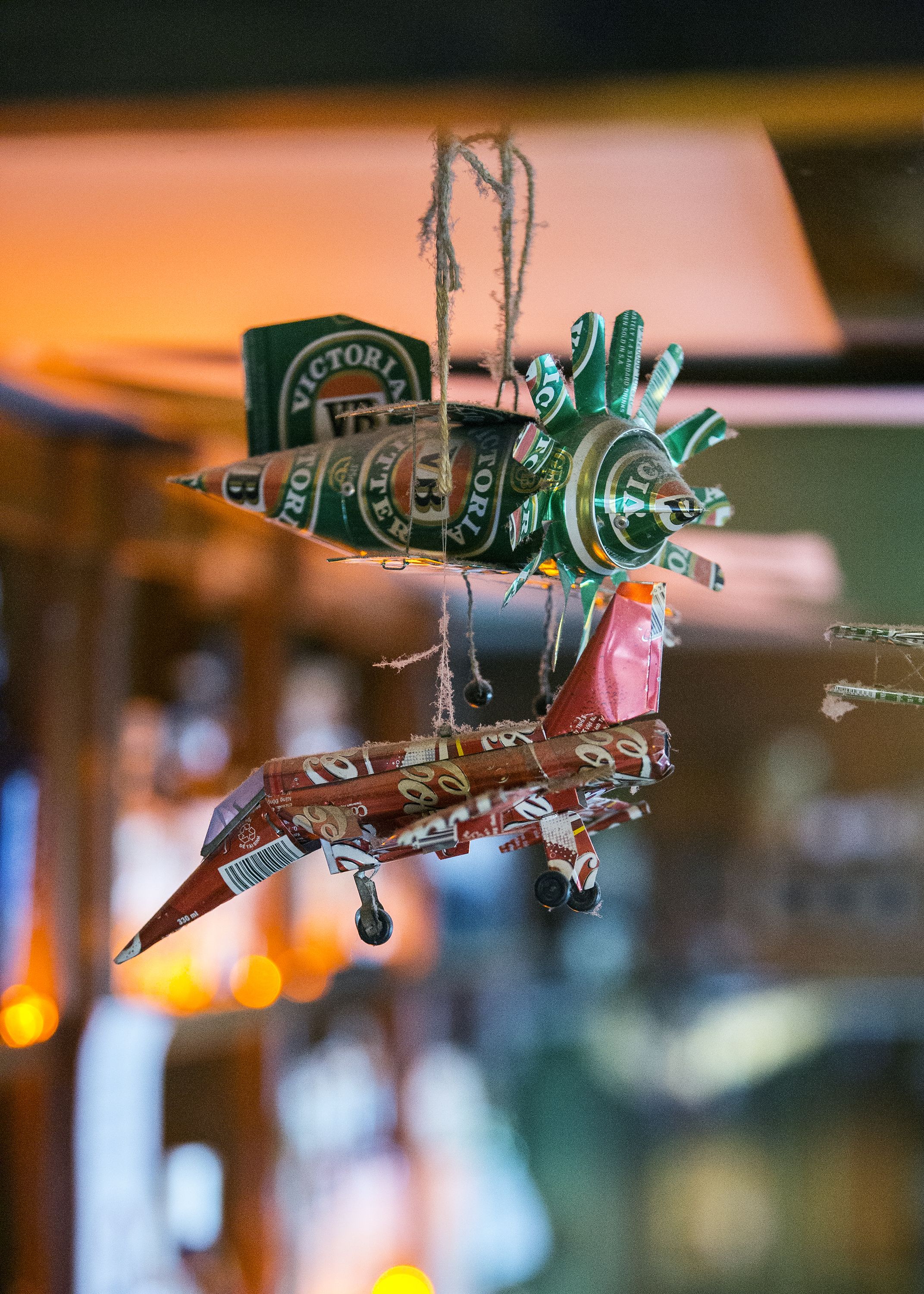 A decorative hanging ornament made from beer cans.