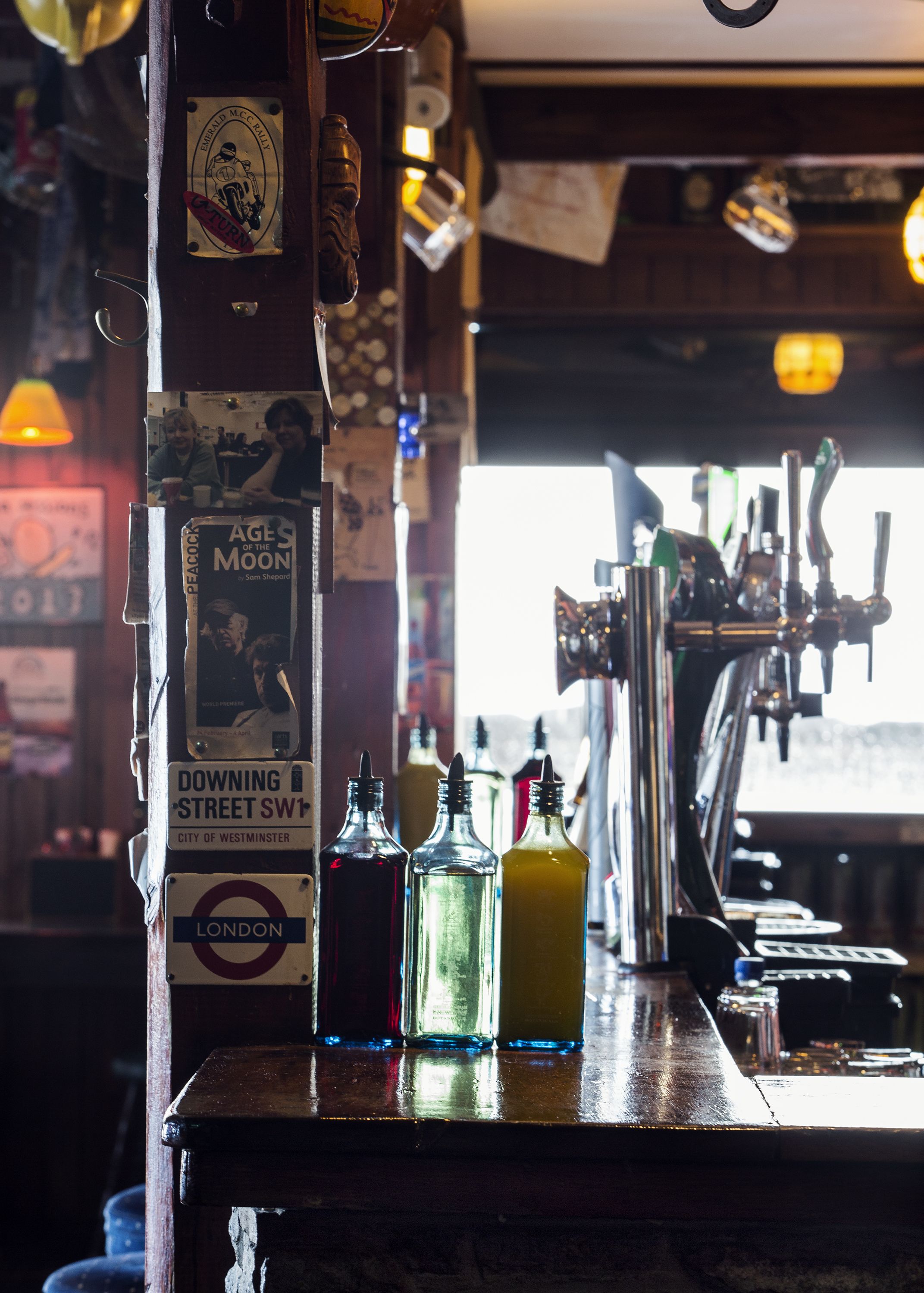 A bar with a tap and bottles on the counter.