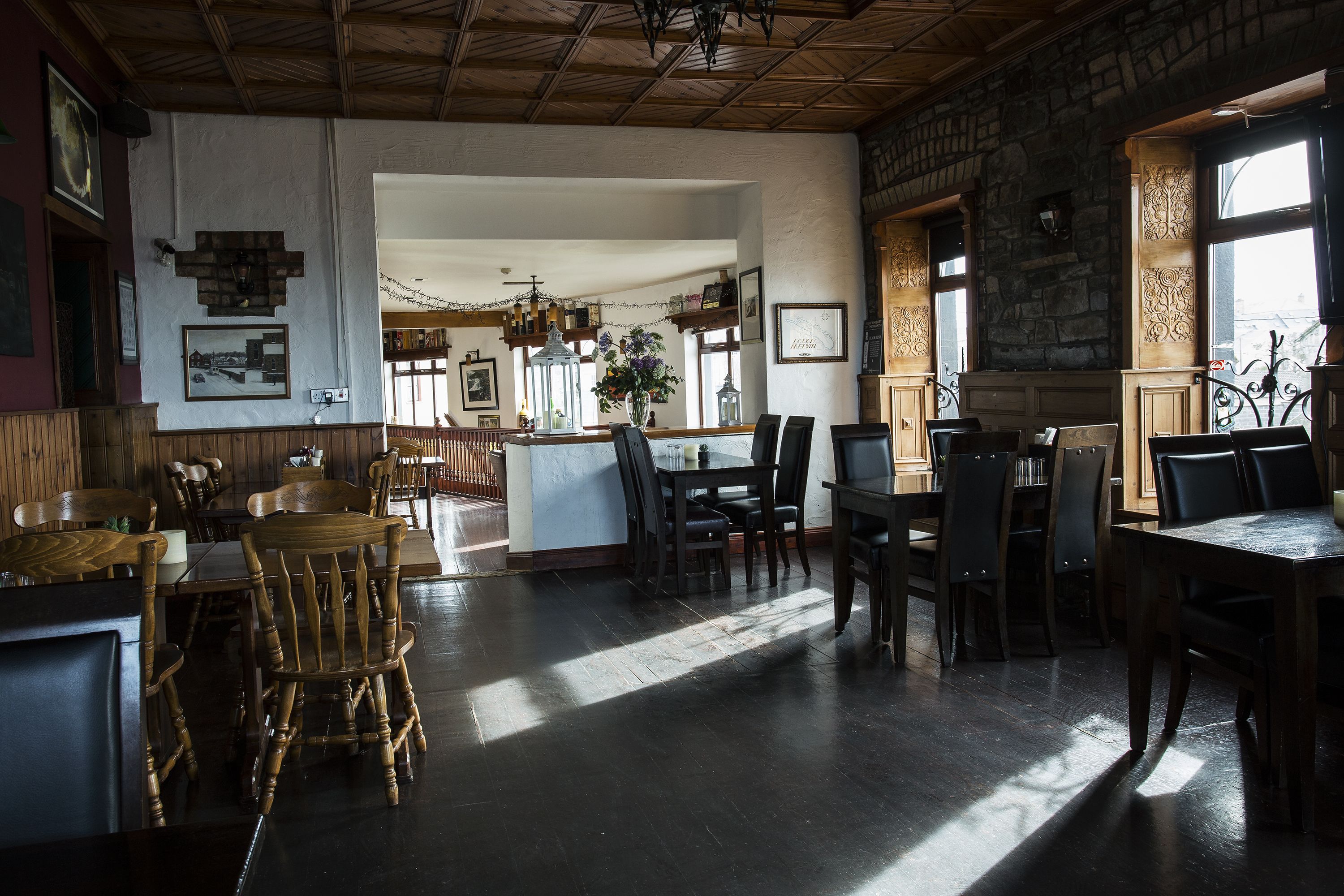 A spacious dining area with wooden furniture and a stone wall.
