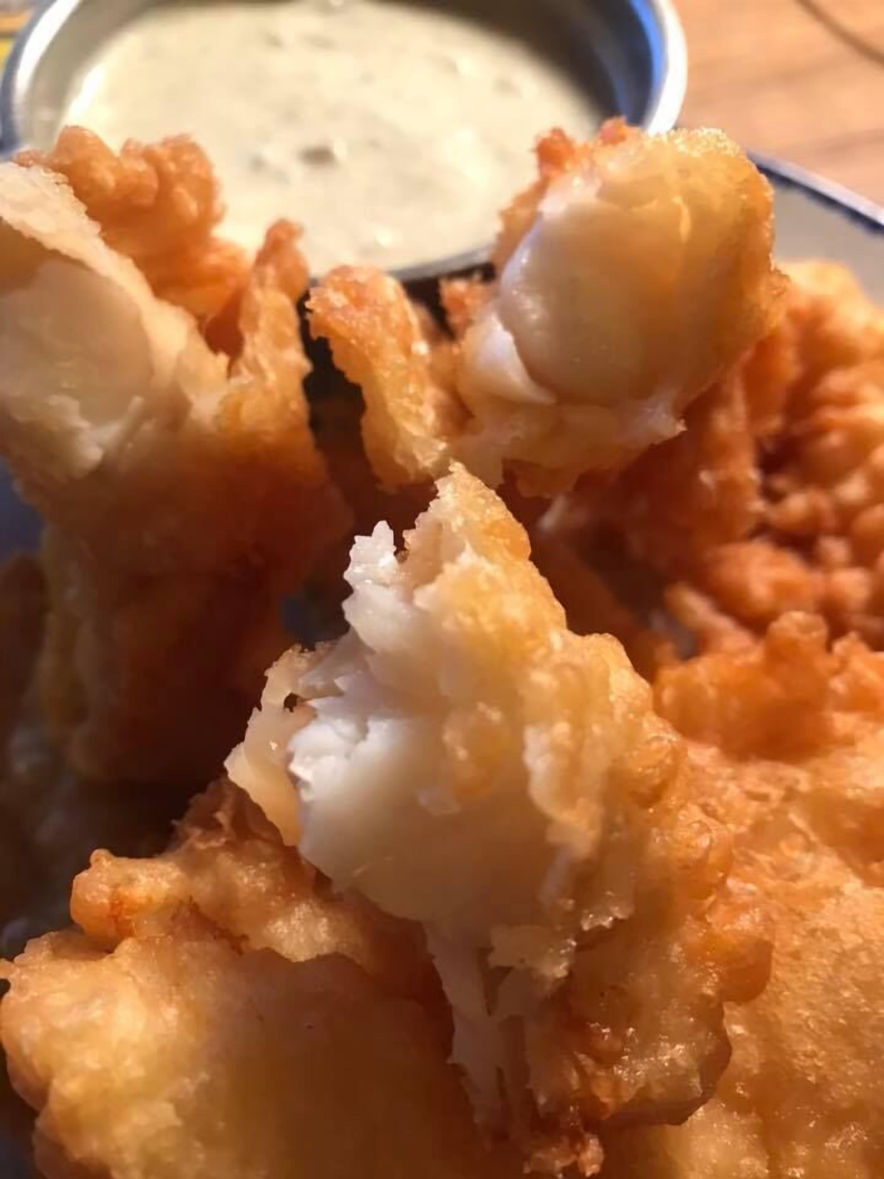 A plate of fried food with a dipping sauce.