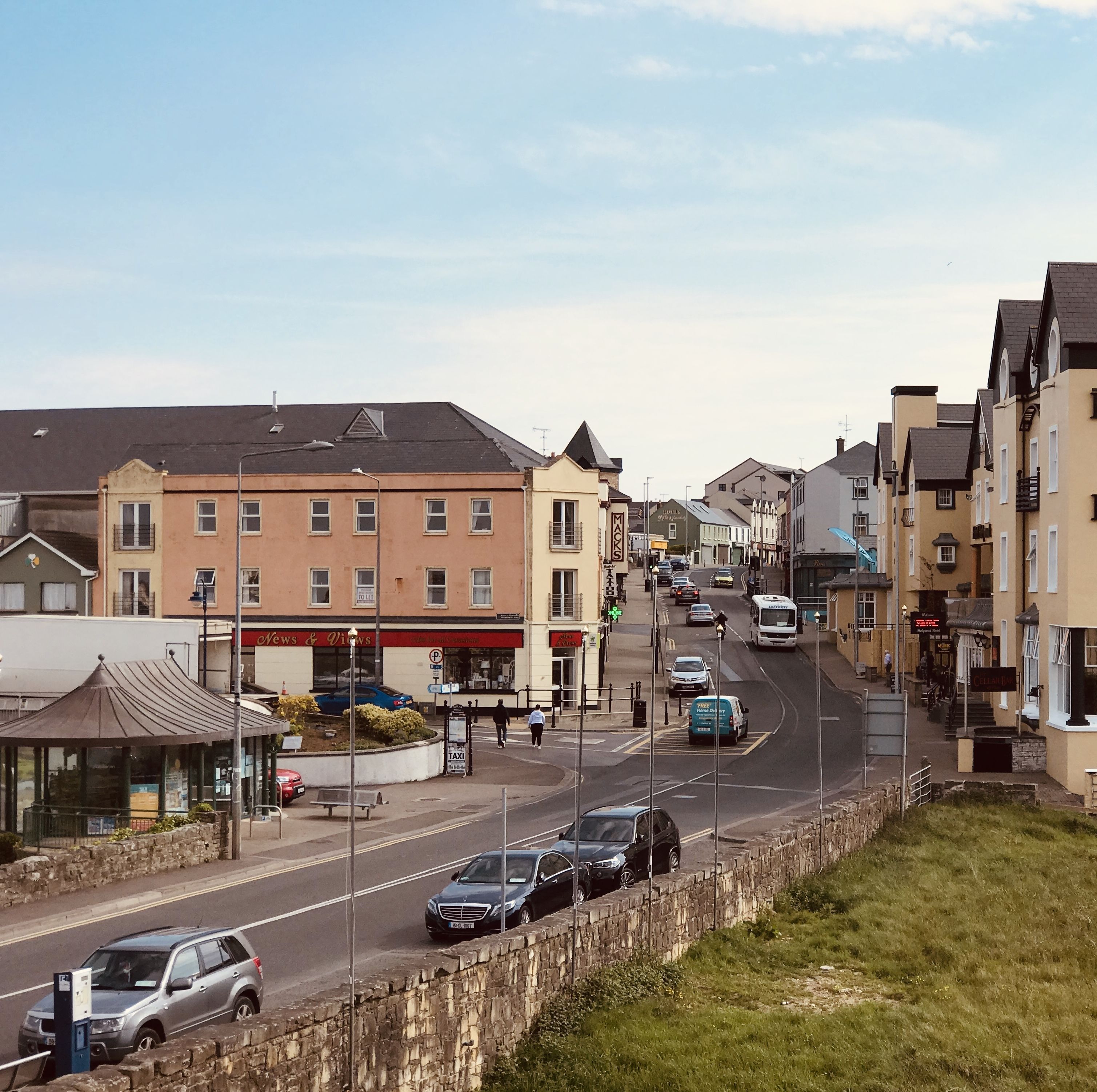 Une vue de rue avec une rangée de bâtiments, dont un hôtel portant l’enseigne « Mack ».