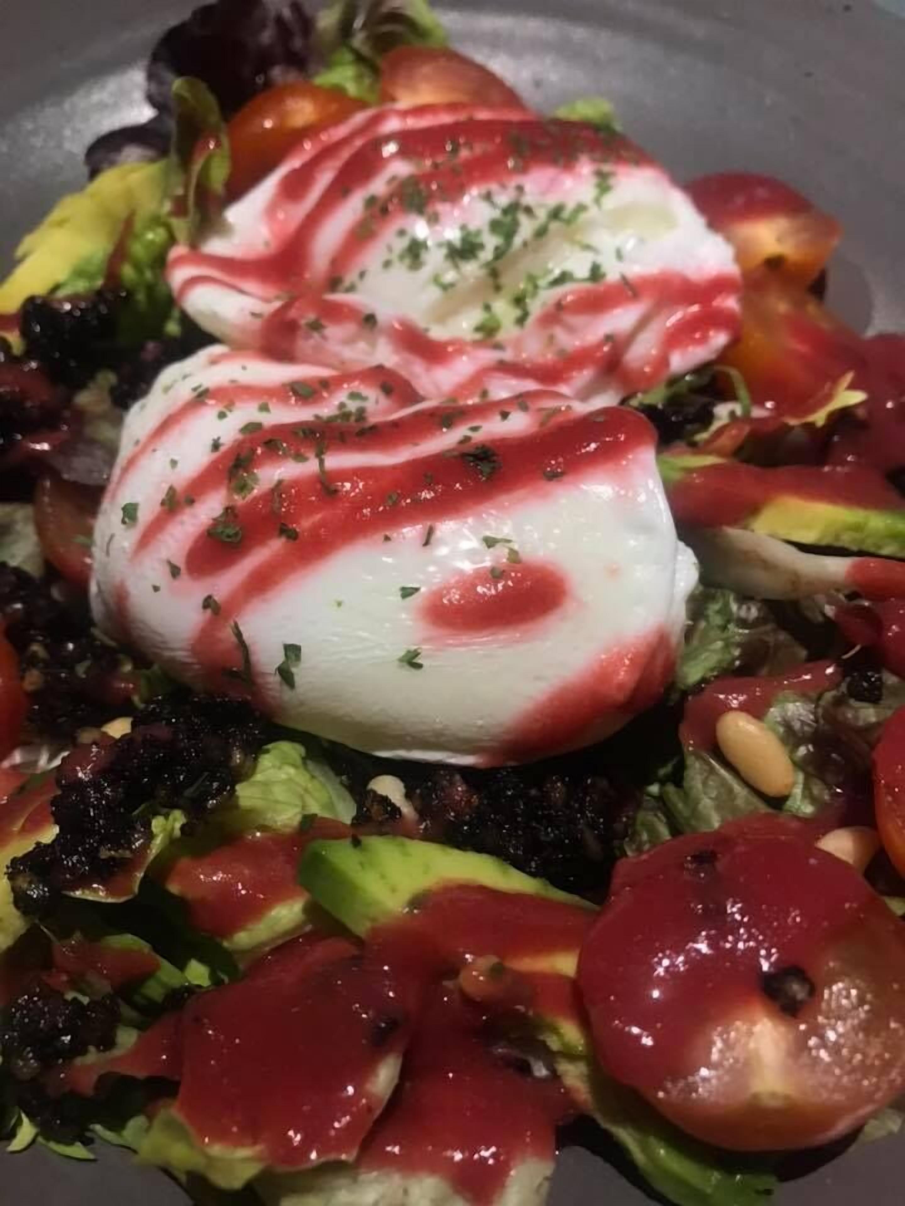 A salad with various vegetables and a poached egg.