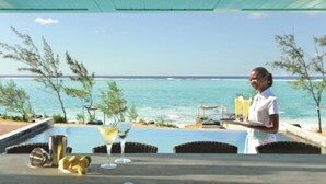 Un restaurante frente al mar, con vista al océano, piscina y terraza.