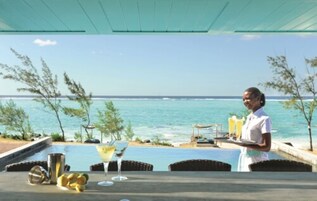 Una piscina al aire libre, una piscina con borde infinito, sombrillas