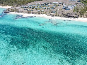 An aerial view of a coastal resort with multiple bungalow-style accommodations, a sandy beach, and clear turquoise waters. - Constance Tekoma. Rodrigues (Rodrigues Island)