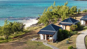 Una propiedad costera con varias construcciones, una playa y una vista despejada del océano.