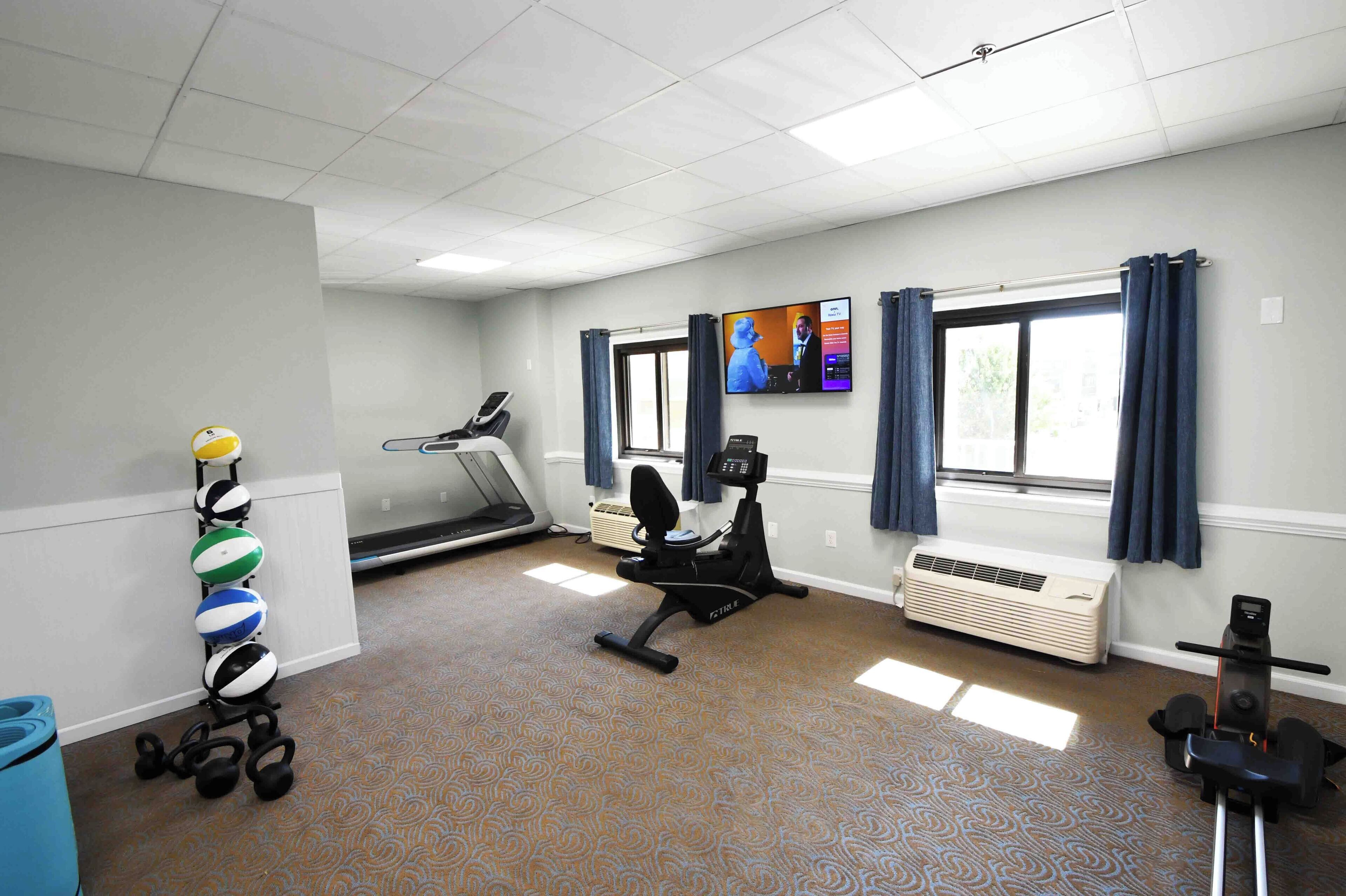 A fitness room with exercise equipment, a treadmill, and a stationary bike.