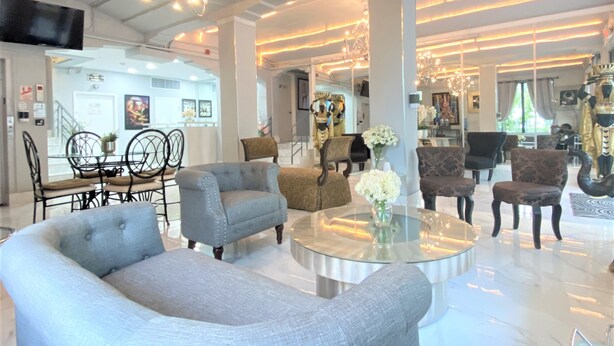 A spacious living area with modern furniture, a chandelier, and a dining area with a glass table. - Notebook Miami Beach (Miami Beach)