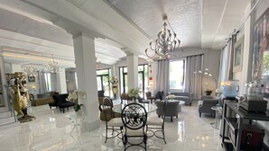 A spacious, well-lit interior with a marble floor, a dining area with a glass table, and a living area with a sofa and armchairs. - Notebook Miami Beach (Miami Beach)