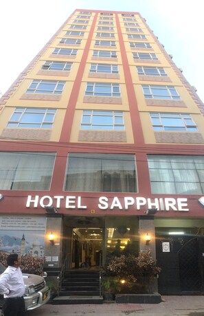 A tall hotel building with the name "HOTEL SAPPHIRE" prominently displayed at the entrance. - Hotel Sapphire (Dar es Salaam)