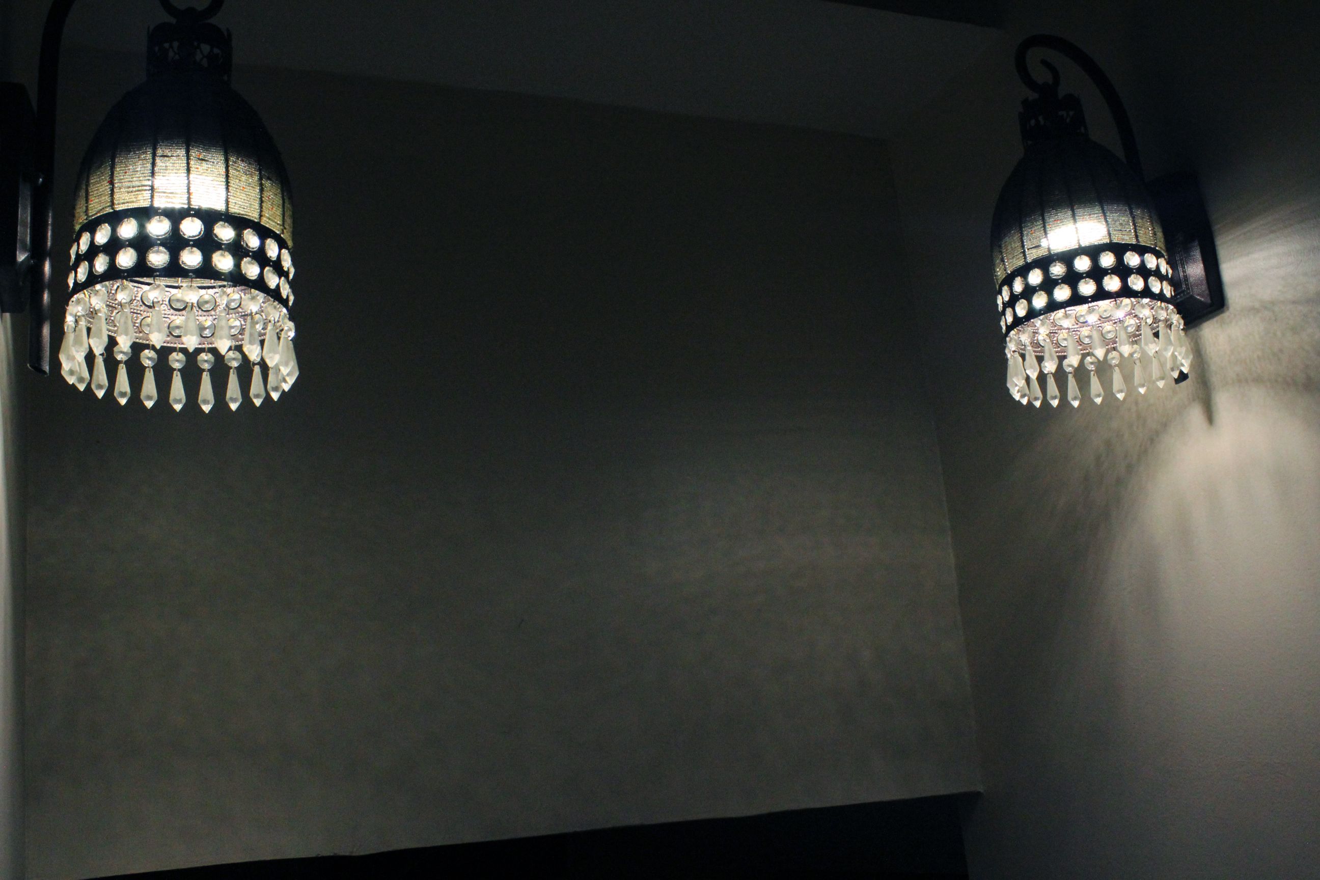 Two wall-mounted light fixtures with crystal details.