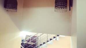 Una escalera con barandilla de metal y sillas de madera.