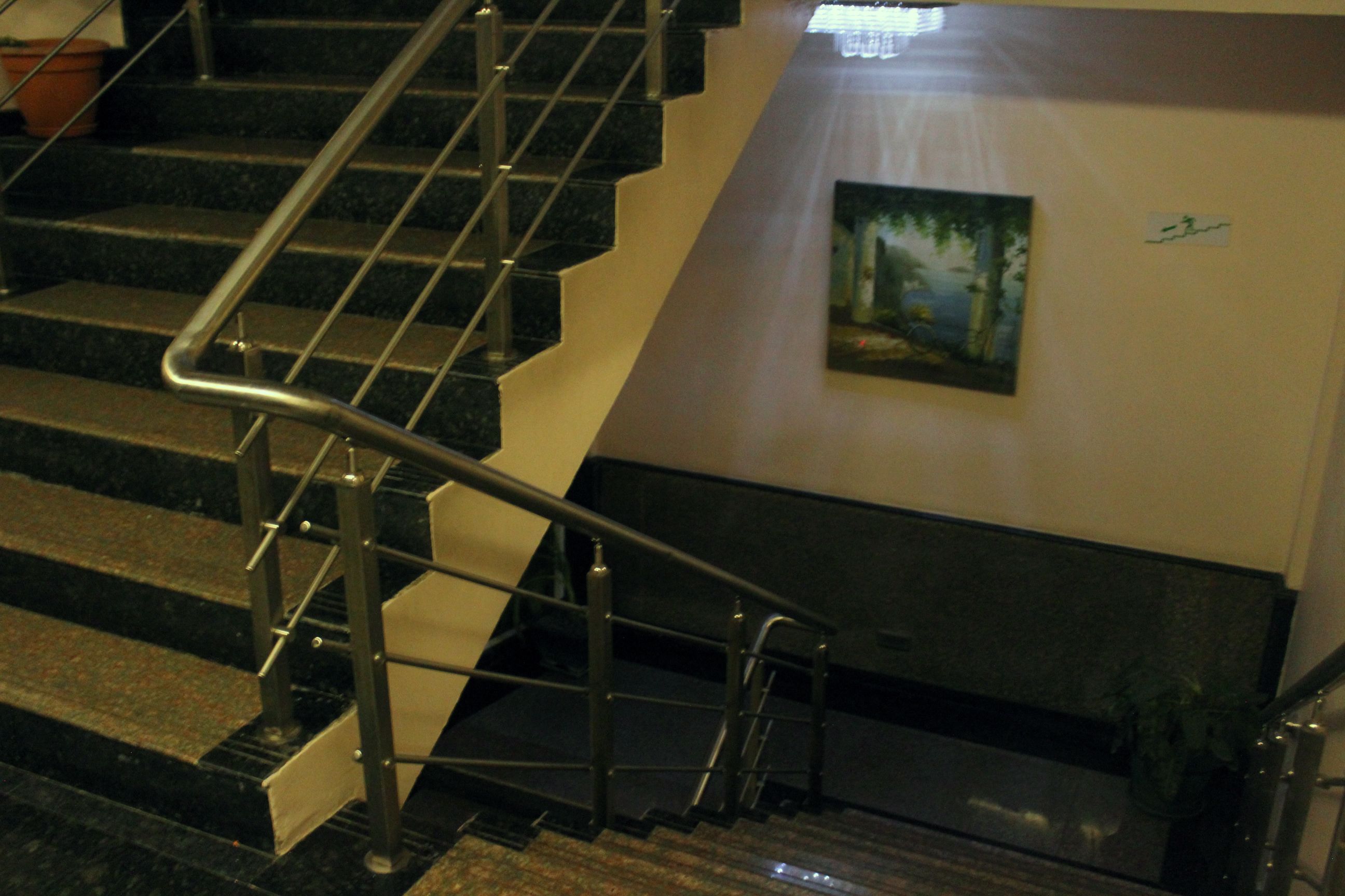 A staircase with metal railings and a painting on the wall.