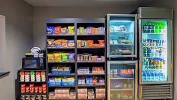 A vending machine stocked with snacks and beverages, including chips, cookies, and bottled drinks.