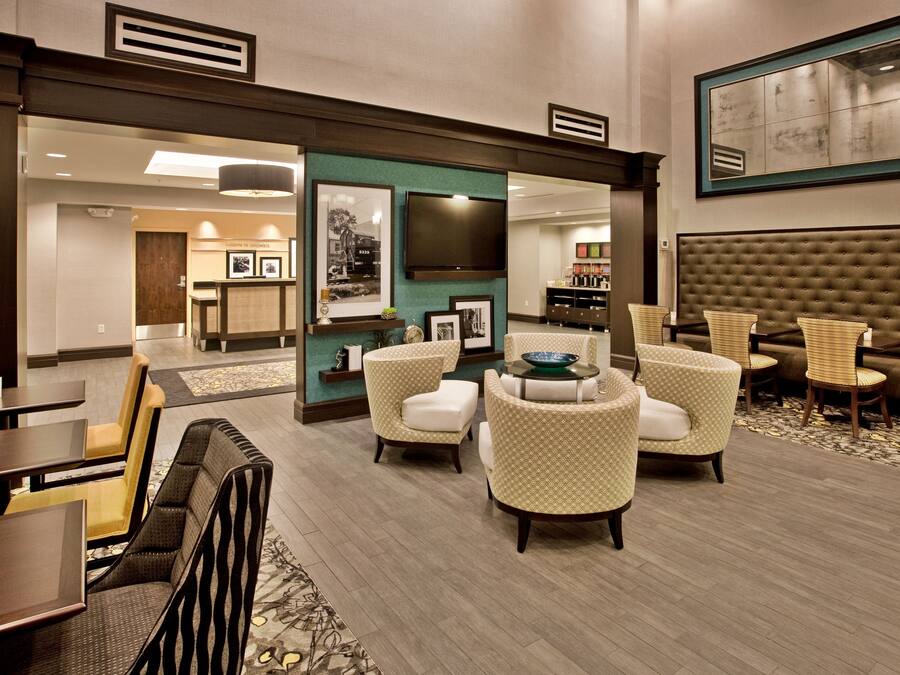 Een hotel lobby met een zithoek, een open haard en een televisie.