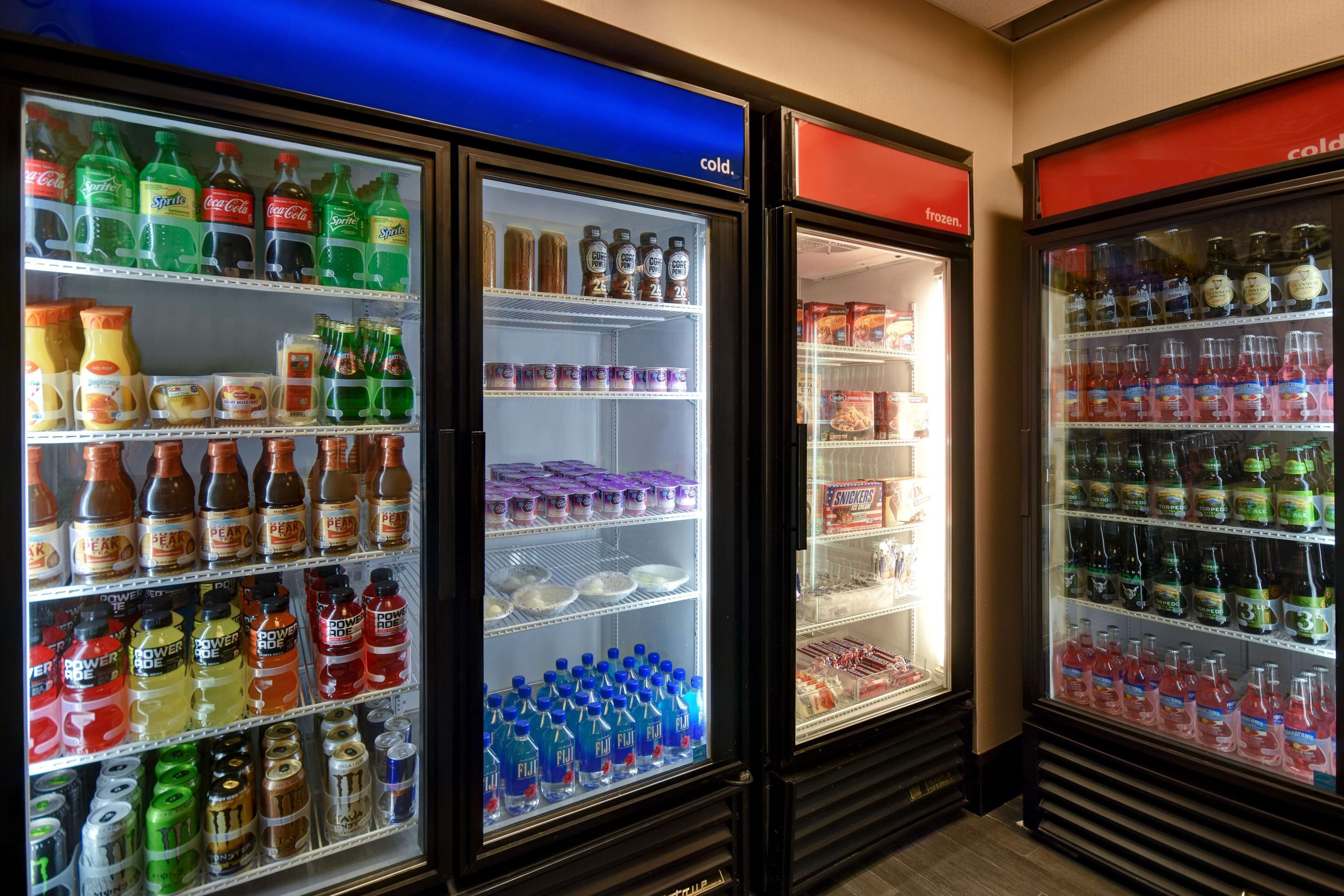 Uma fileira de refrigeradores com diversas bebidas e lanches.