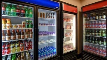 Uma fileira de refrigeradores com diversas bebidas e lanches.