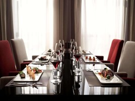 Una larga mesa de comedor con múltiples platos de comida, copas de vino y cubiertos.