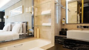 A modern bathroom with a large mirror, a bathtub, a vanity with a sink, and a shower area. - Pullman Wuxi New Lake (Wuxi)