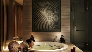 A modern bathroom with a freestanding bathtub, decorative elements, and a large wall art piece.