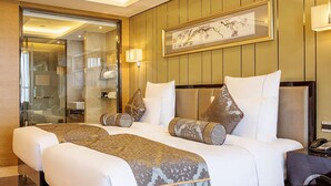 A hotel room with a large bed, a bedside table with a lamp, a framed artwork on the wall, and a glass door leading to a bathroom. - Pullman Wuxi New Lake (Wuxi)