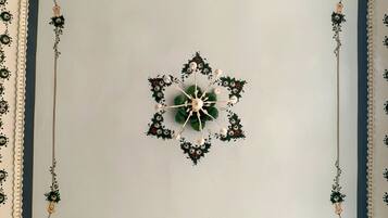 A ceiling with a central floral design surrounded by a decorative border.