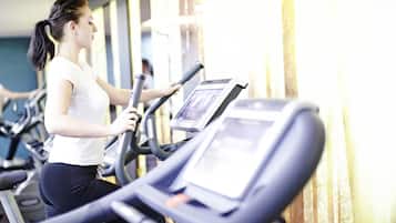 Ein Fitnessstudio mit Laufbändern und einer Person, die eines benutzt.