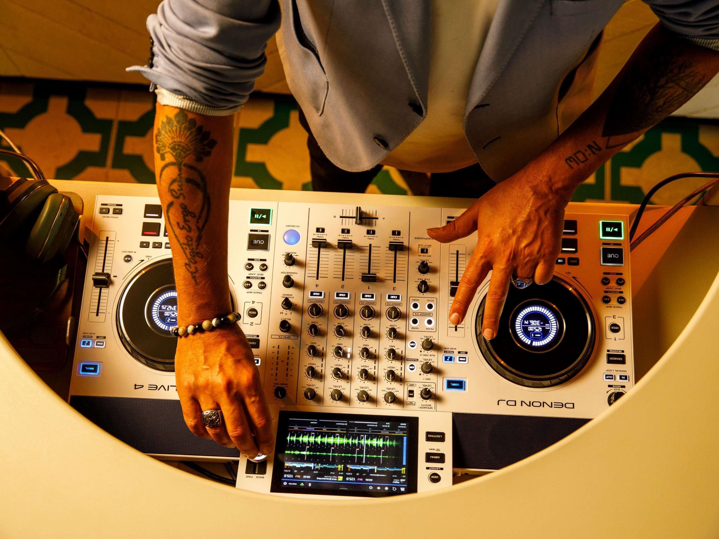 Ein DJ-Pult mit Mischpult, Kopfhörern und einem digitalen Bildschirm.
