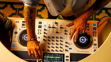 Ein DJ-Pult mit Mischpult, Kopfhörern und einem digitalen Bildschirm.