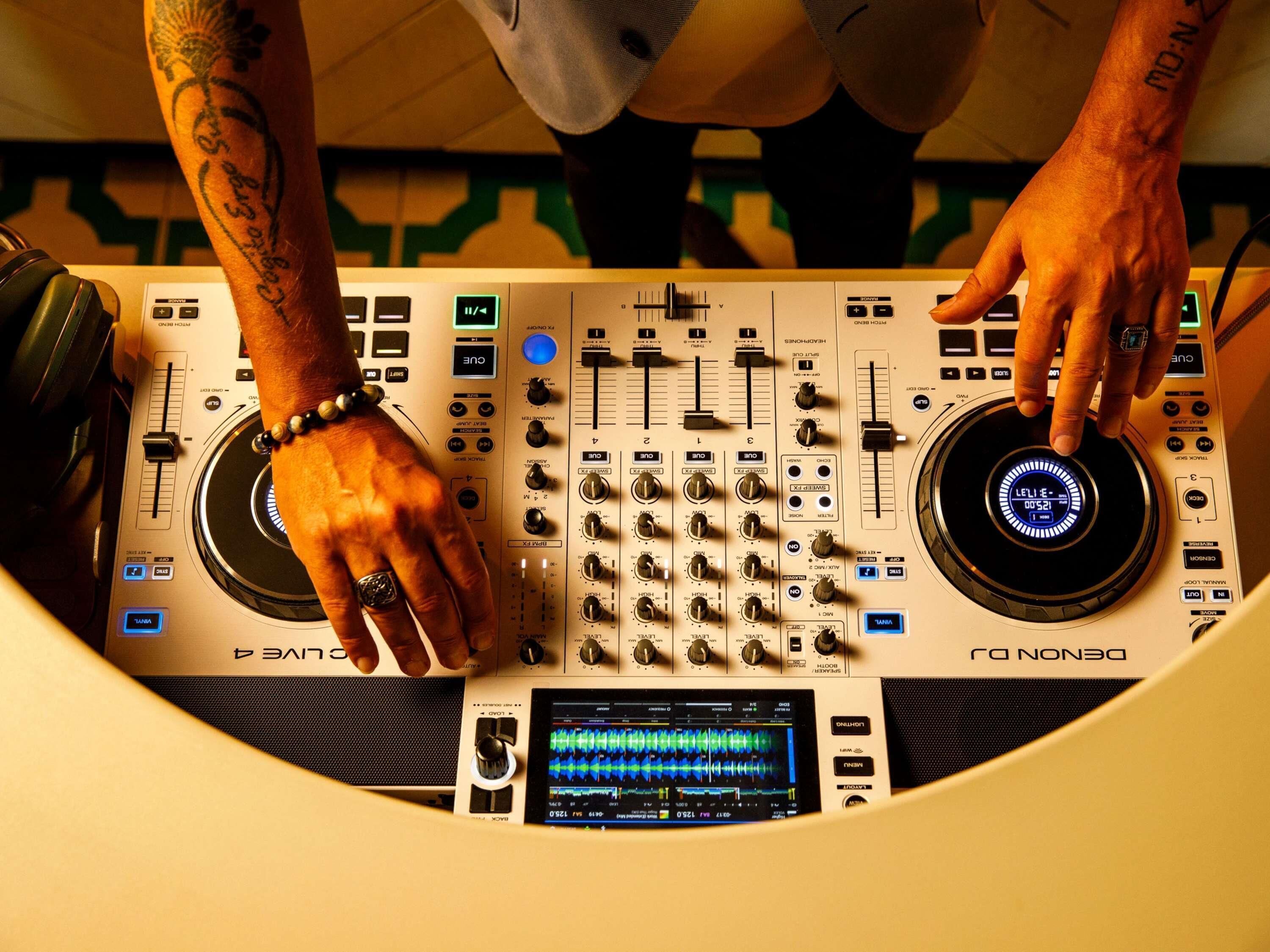A DJ mixing console with multiple knobs, sliders, and a digital display.