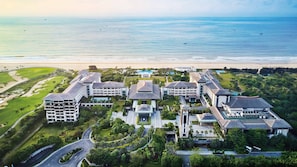 A resort with multiple buildings, a golf course, and a beach view. - Crowne Plaza Hailing Island by IHG (Yangjiang)