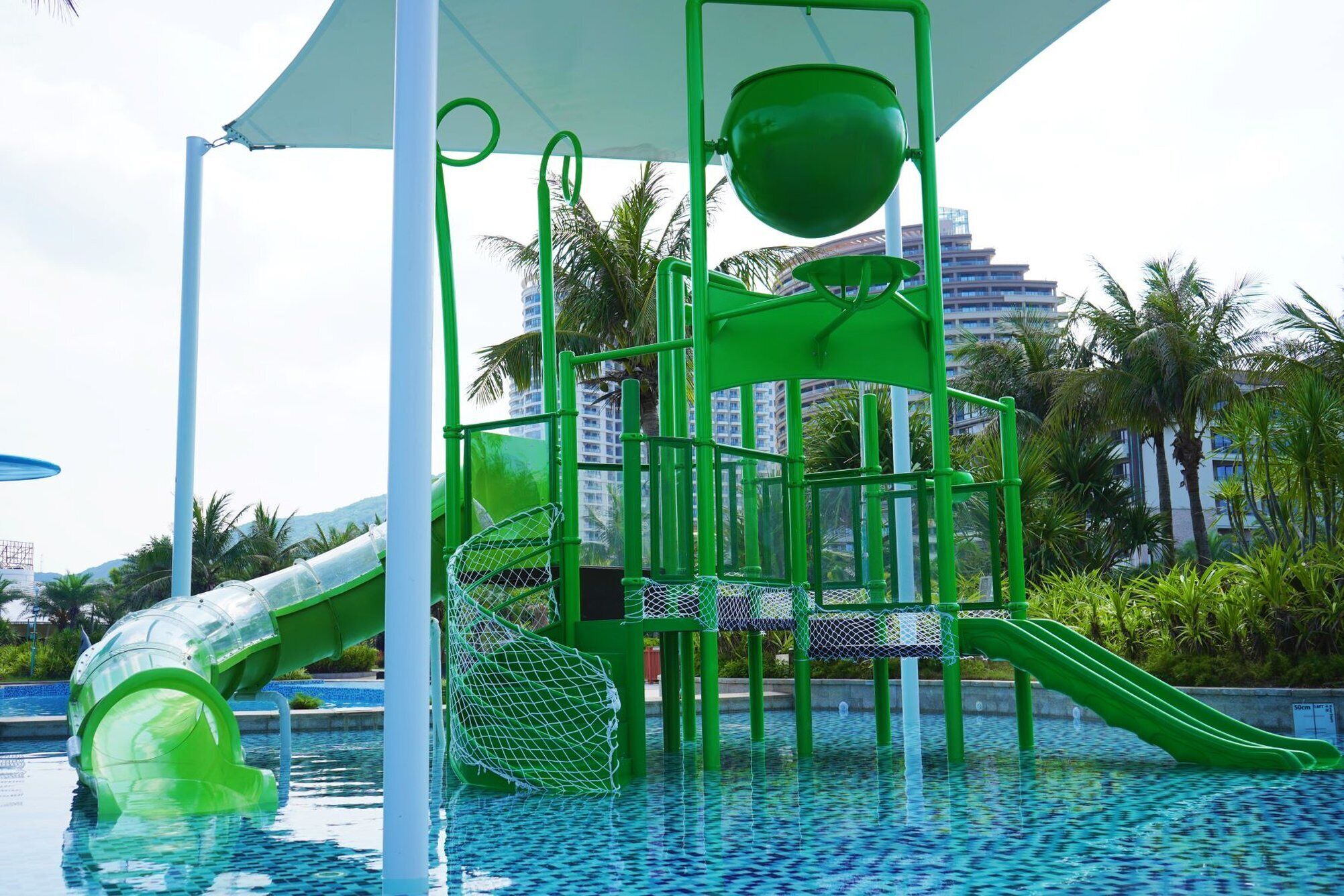 A children's play area with slides and climbing structures over a pool.