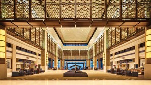 A spacious lobby with a central sculpture, high ceilings, and patterned glass windows. - Crowne Plaza Hailing Island by IHG (Yangjiang)