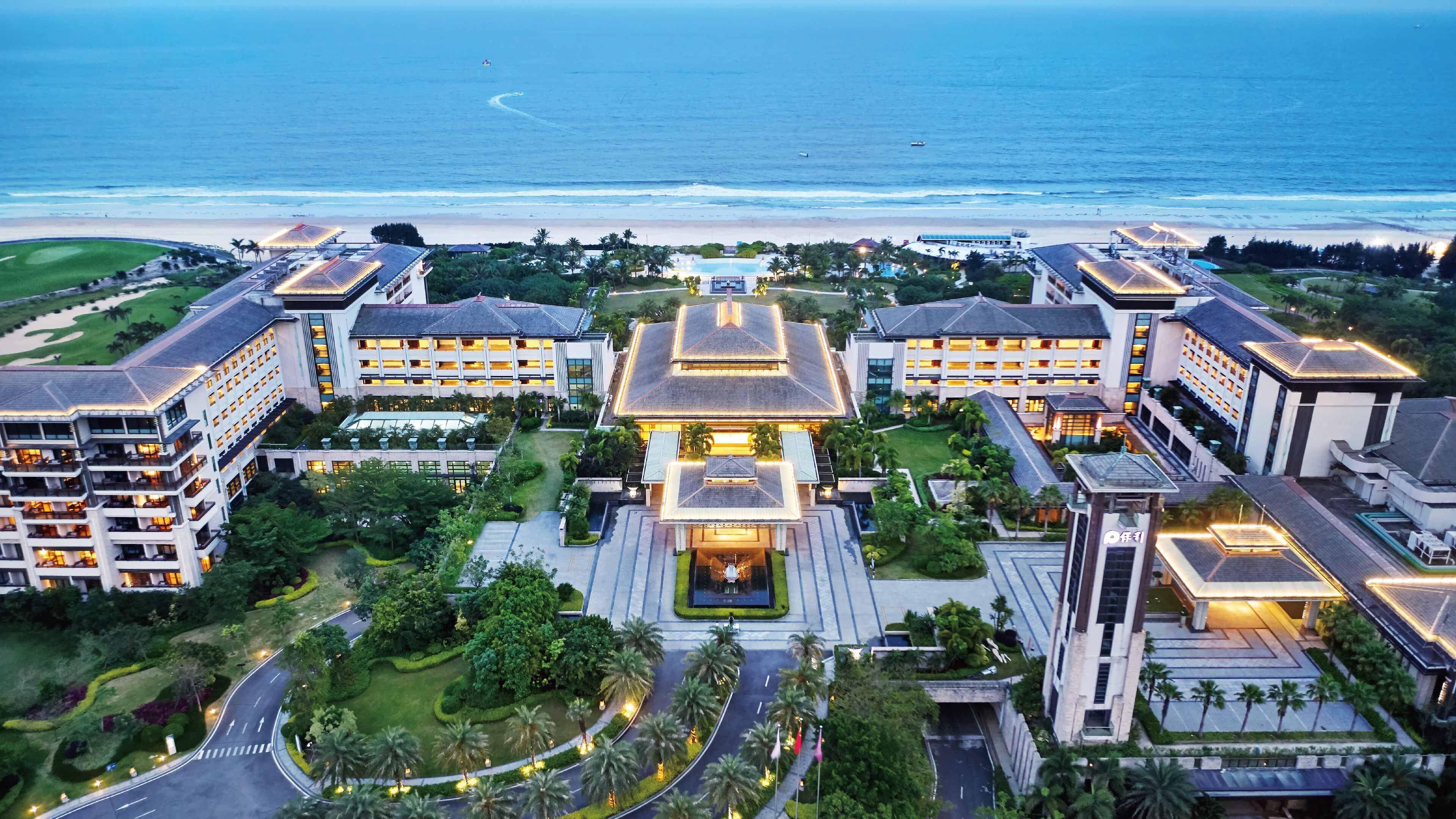 A hotel with multiple buildings, a central courtyard, and a view of the beach.
