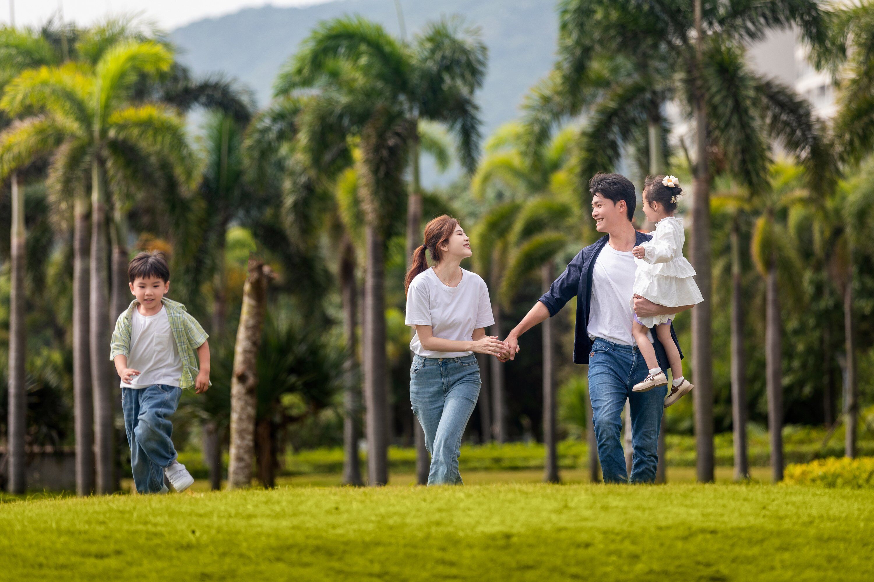 Una familia caminando en un parque con palmeras.