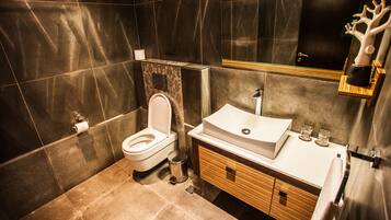 Un baño moderno con inodoro, lavabo y espejo.